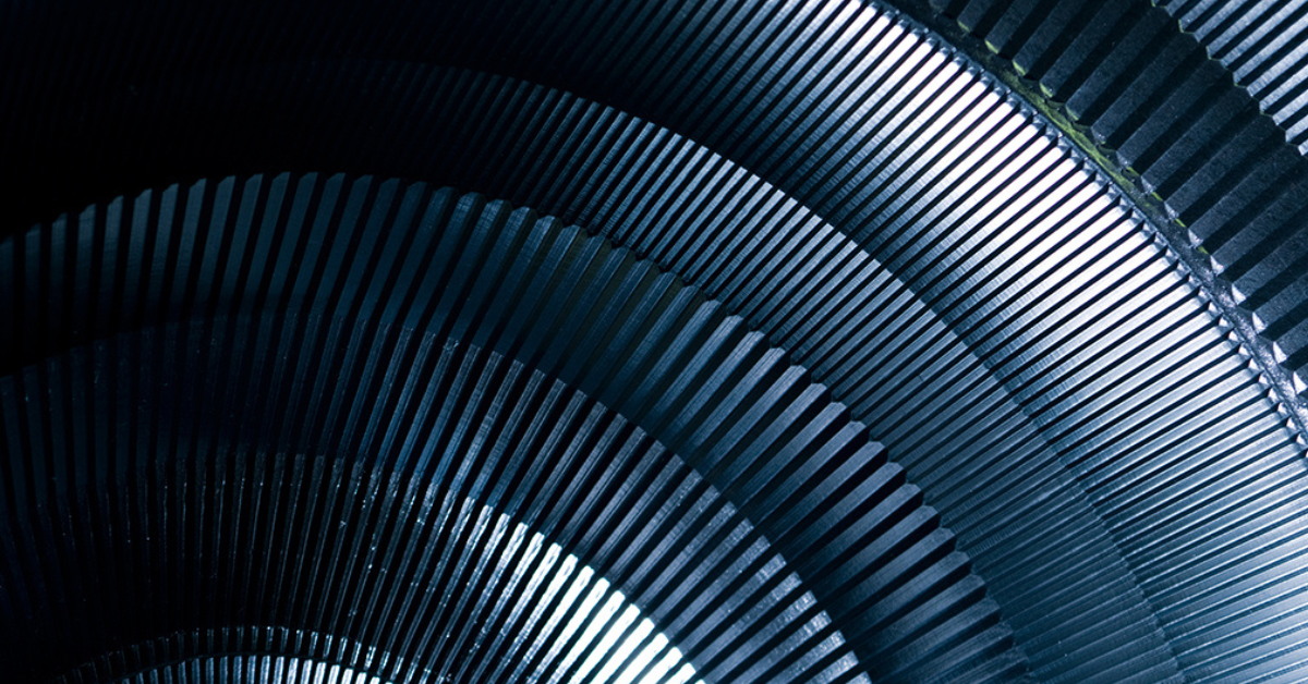 Close-up of dark metallic, ribbed, semicircular structures layered in a radial pattern, creating a repeating geometric and industrial texture with dramatic lighting and shadows.